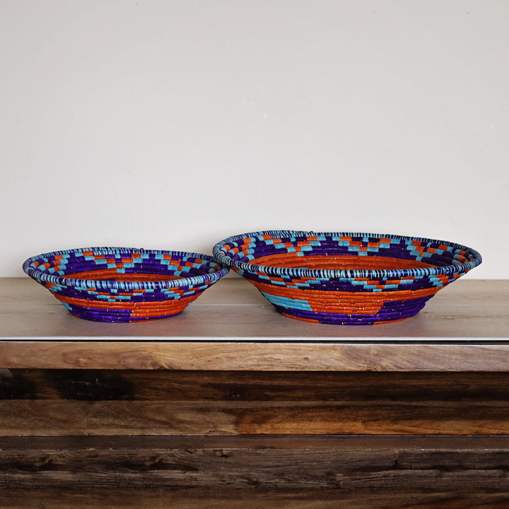 Side view of a Blue, Turquoise & Red Bukedo and Raffia bowl handcrafted in Uganda from banana leaf stalks and palm raffia.