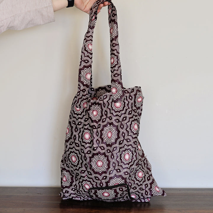 Patterned tote bag held by a person against a plain background, african printed, reusable.