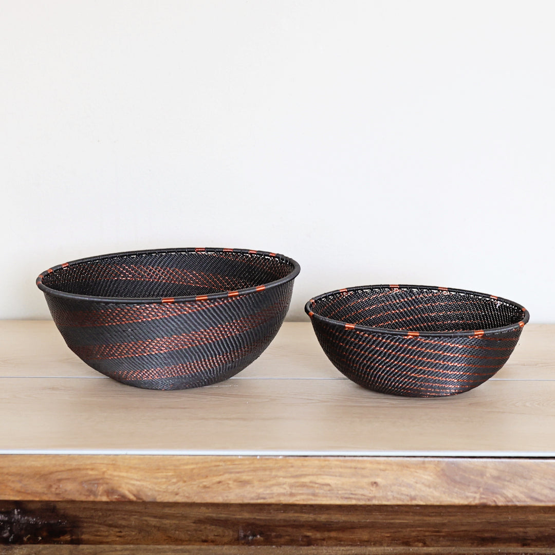 Side view of a Copper & Black Zulu Bowl featuring intricate spiral weaving and copper wire detailing by South African artisans.