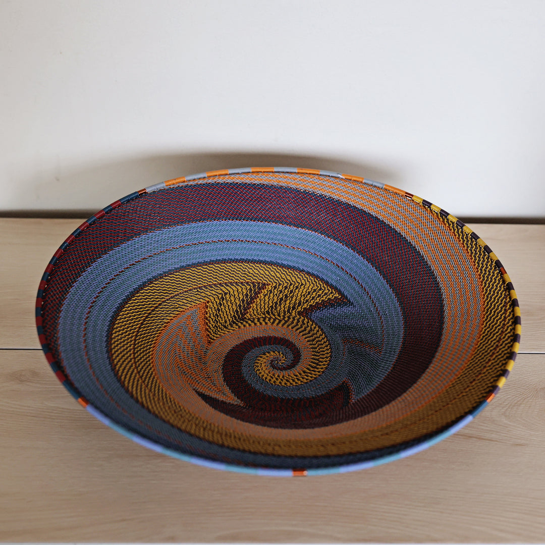 Cove Zulu Wire Extra Large Shallow Baskethandwoven in South Africa with intricate woven patterns in layered coastal and earthy tones.