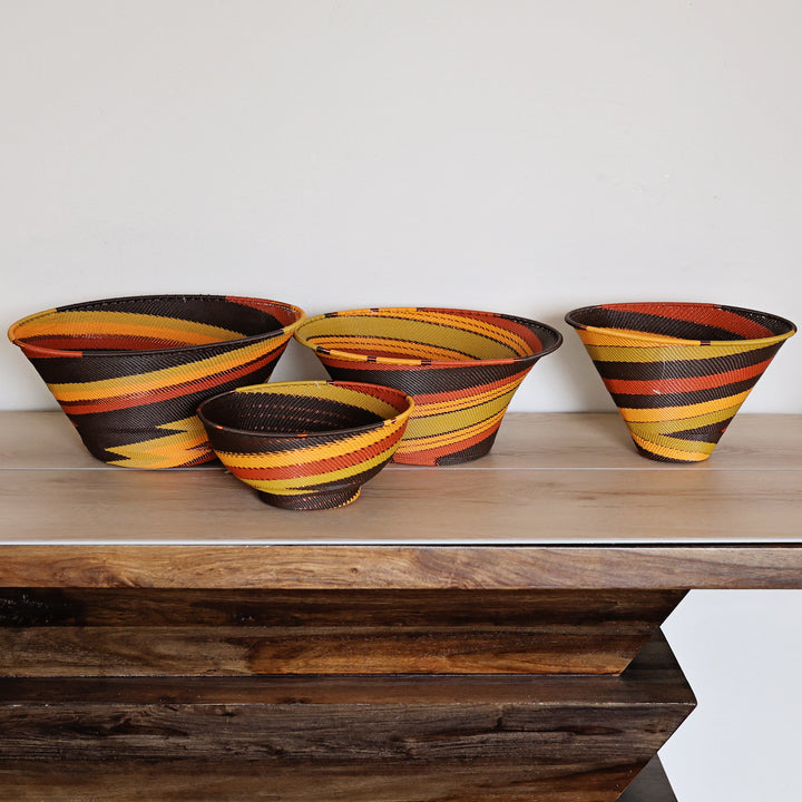 Side view of a Dark Earth Zulu Medium Deep Funnel Bowl featuring warm earth tones and intricate handwoven wire craftsmanship by South African artisans.