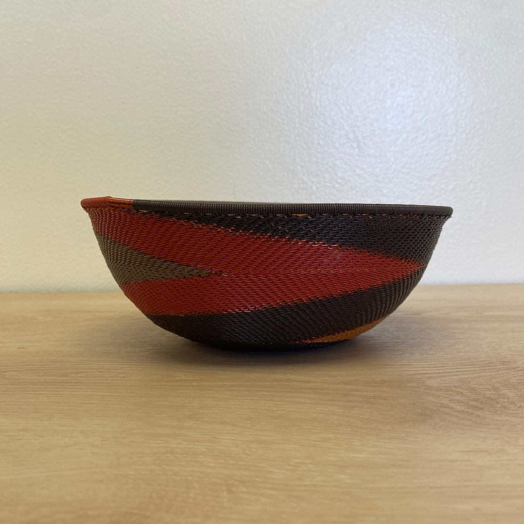 South African Zulu wire bowl basket in the Dark Earth colorway with rich brown, rust, orange and golden woven details.