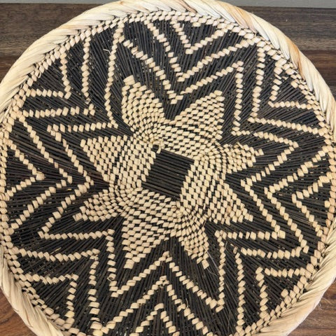 Decorative basket tray with geometric woven design handmade by artisans in Africa.