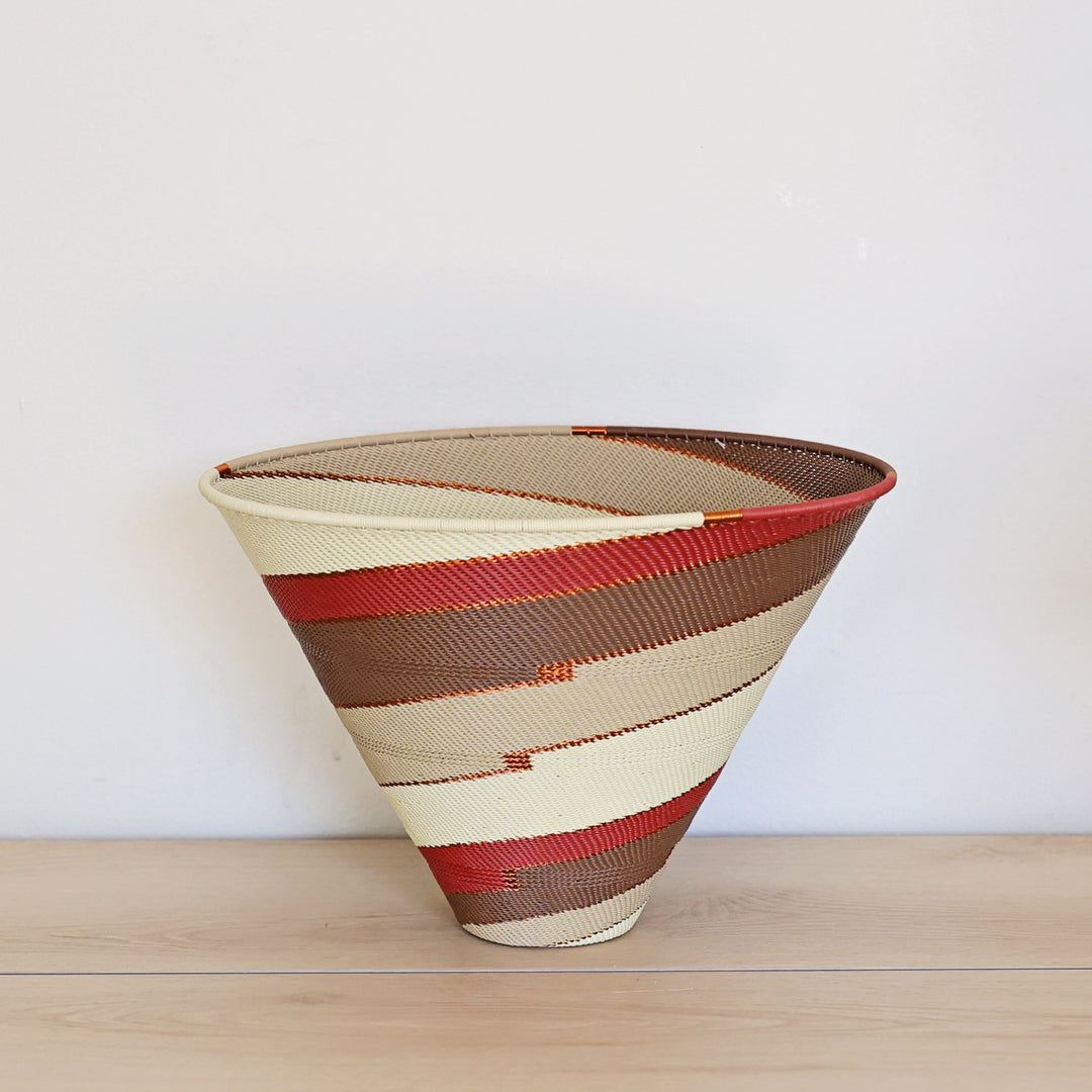 Desert Zulu Large Deep Funnel Bowl handwoven in South Africa with ivory, rust, brown, and warm neutral tones in a spiral pattern.