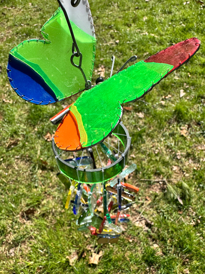 Colorful butterfly-shaped wind chime on a grassy background
