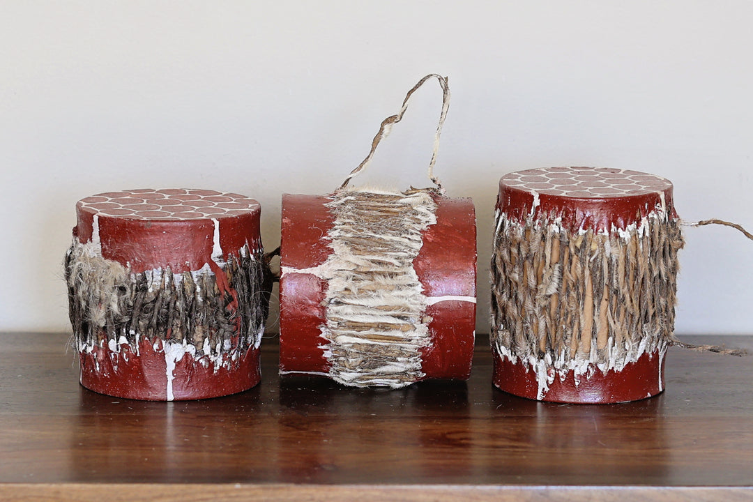 Small handmade red Kenyan drum with giraffe print painted on the goat skin and made from traditional carved wood.