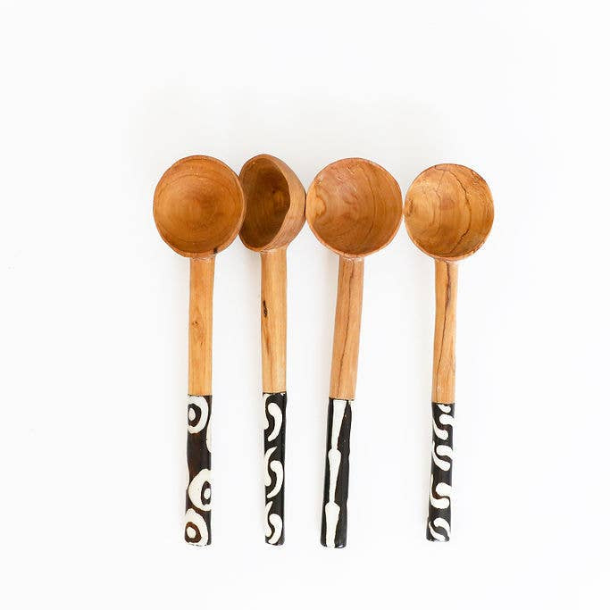 Close-up of bone-handled fork and spoon from a handcrafted wood and bone cutlery set.