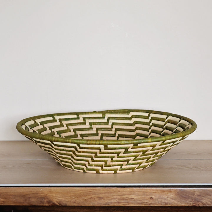 Side view of a Green & White Bukedo and Raffia bowl handcrafted in Uganda from banana leaf stalks and palm raffia with woven green and white patterns.