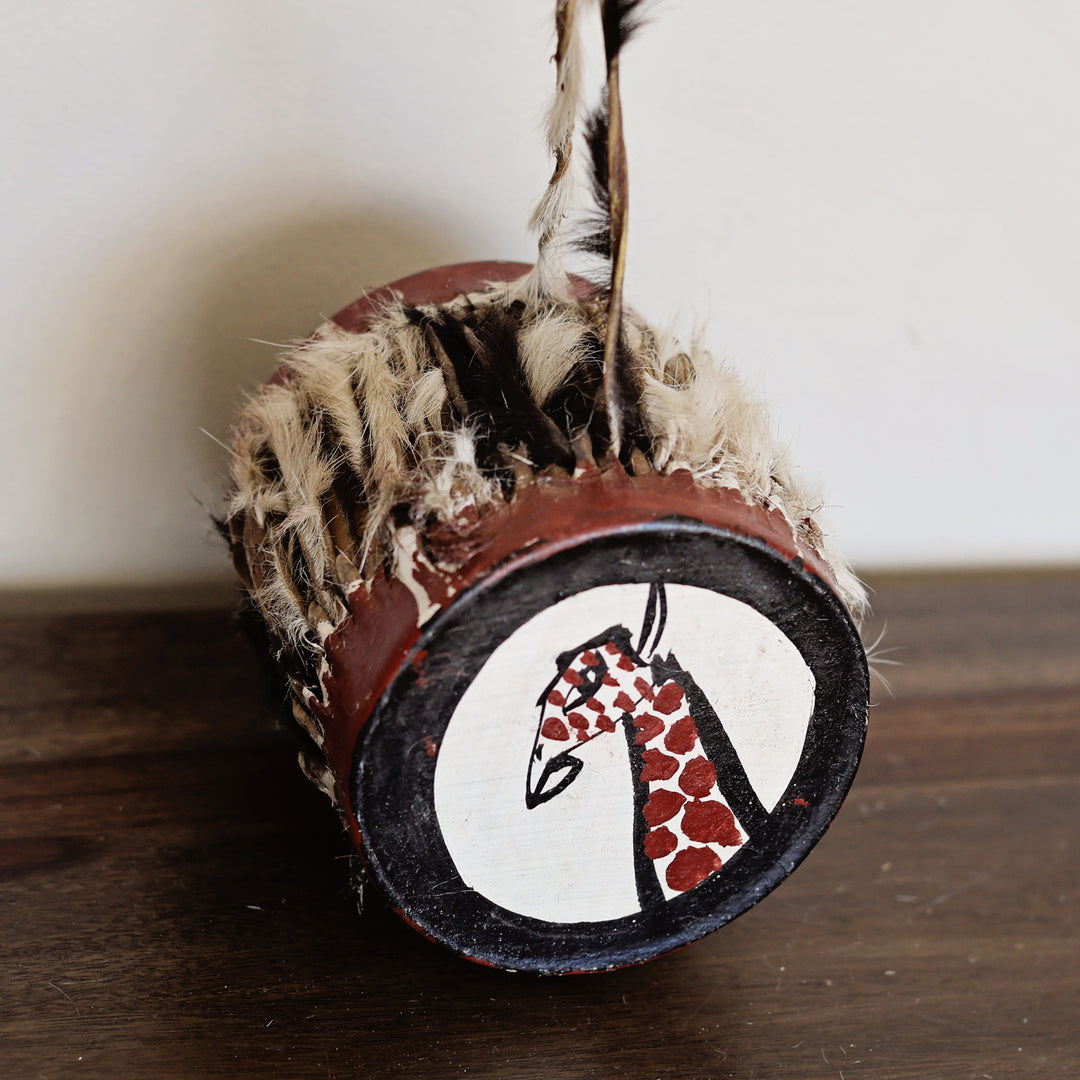 Handmade African percussion drum for music and cultural learning, with hand-painted giraffe head on top.