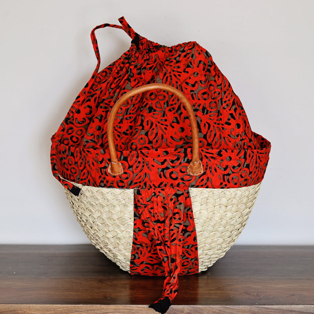 Alt: Detail of assorted African fabric lining and patterned palm leaf weaving on the Kikapu Janet Tote Bag.