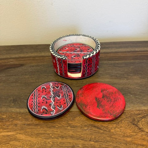 Close-up of assorted Kenyan soapstone coasters showing the red color variations and hand-carved texture.