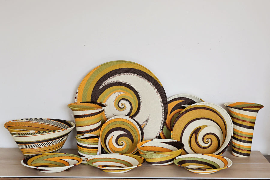 Assorted Light Earth Zulu Wire Baskets handwoven in South Africa in warm ivory, ochre, sage, brown, and rust tones.