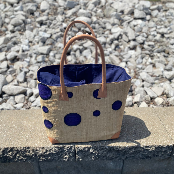 Handwoven Madagascar Dotted Abstract Raffia Tote Bag with colorful dot pattern and tan leather handles.