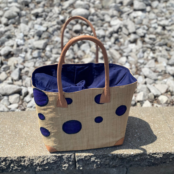 Purple dotted raffia tote bag handwoven in Madagascar with natural palm fibers and leather handles.