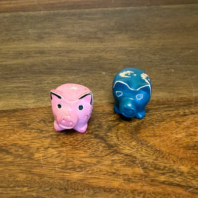 Two small soapstone pig figurines carved from Kisii stone in Kenya.