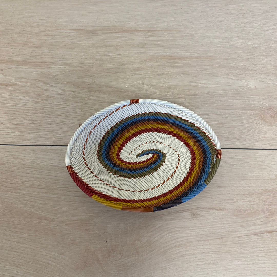 Handwoven Mountain Rainbow Zulu wire oval tray in cream, rust, yellow, olive green, blue and earthy tones.