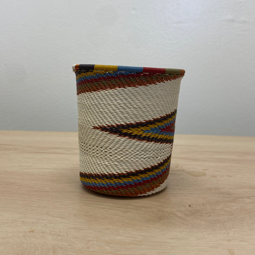 Handwoven Zulu wire wide base cup in the Mountain Rainbow colorway with cream, rust, olive, blue and golden details.
