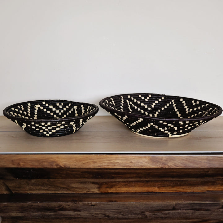 Side view of a Night Sky Bukedo and Raffia bowl handcrafted in Uganda from banana leaf stalks and palm raffia with a black and natural woven design.