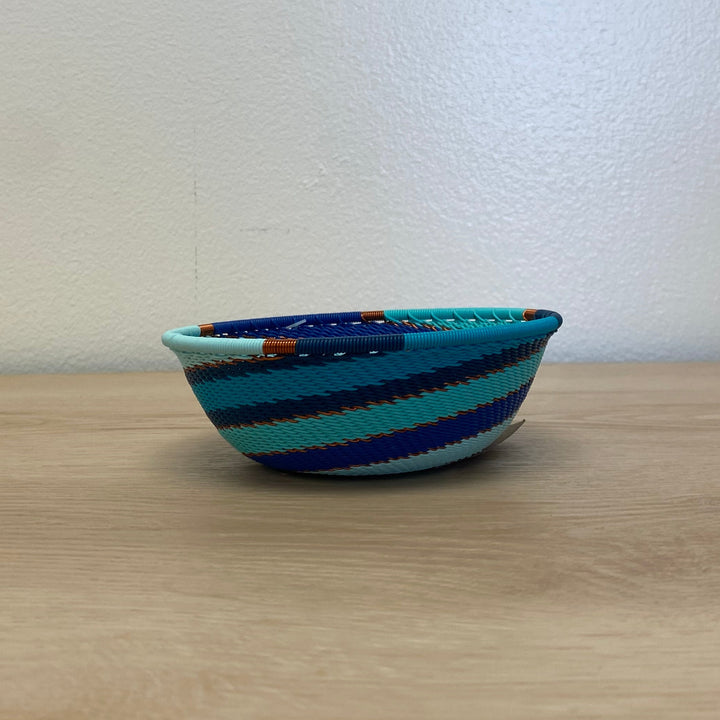 Handwoven Ocean Zulu small wide bowl wire basket featuring an intricate aqua and deep blue spiral design.
