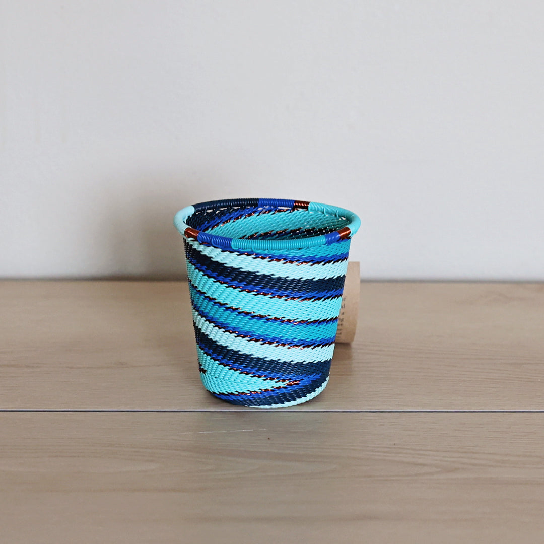 Handwoven Ocean Zulu wide base cup basket with graphic navy, turquoise and aqua woven patterns.