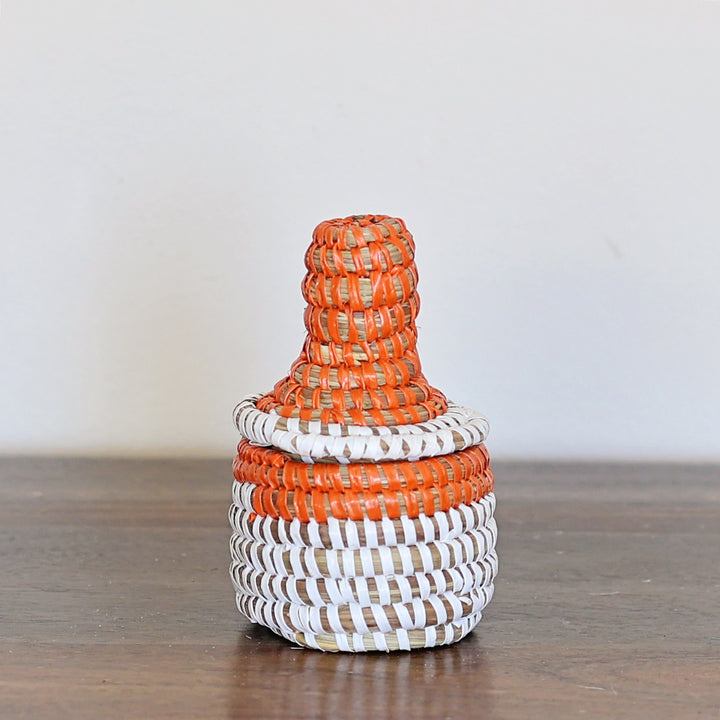 Small orange sweetgrass lidded basket handmade by Senegal artisans.