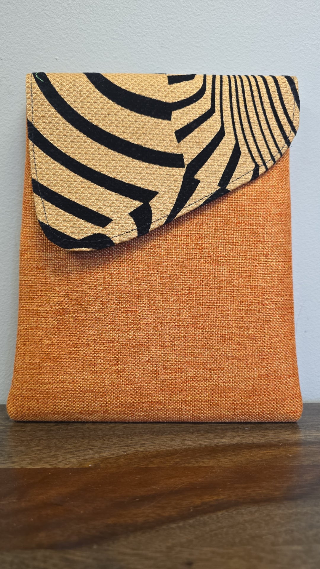 Orange crossbody bag with zebra printed flap.