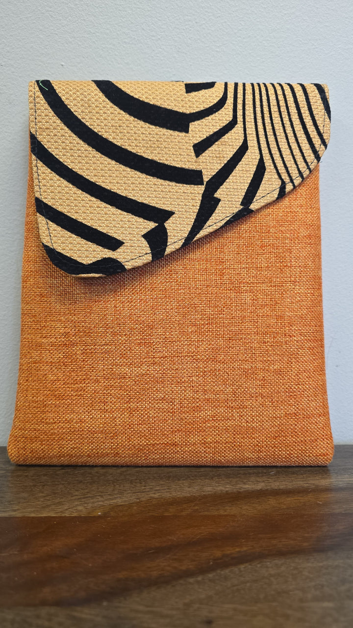 Orange crossbody bag with zebra printed flap.