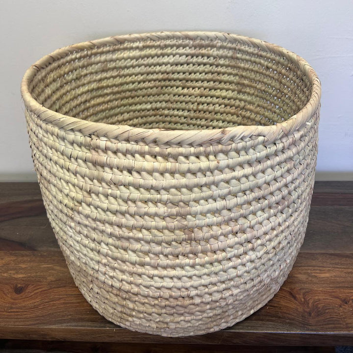 Woven basket on a wooden surface with a plain background, this basket is perfect for organizing. 