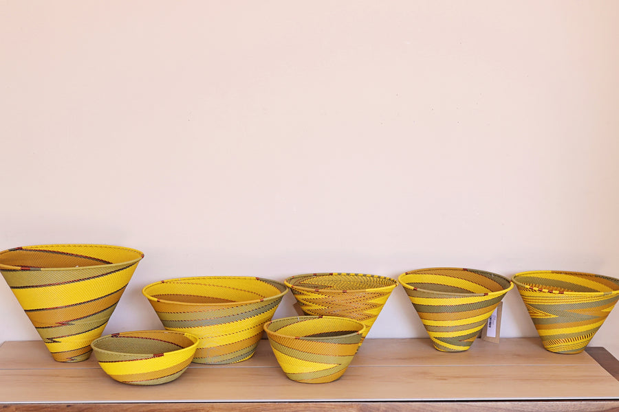 Papaya Zulu Bowl handwoven in South Africa with sunny yellow and papaya orange in a diagonal stripe pattern.