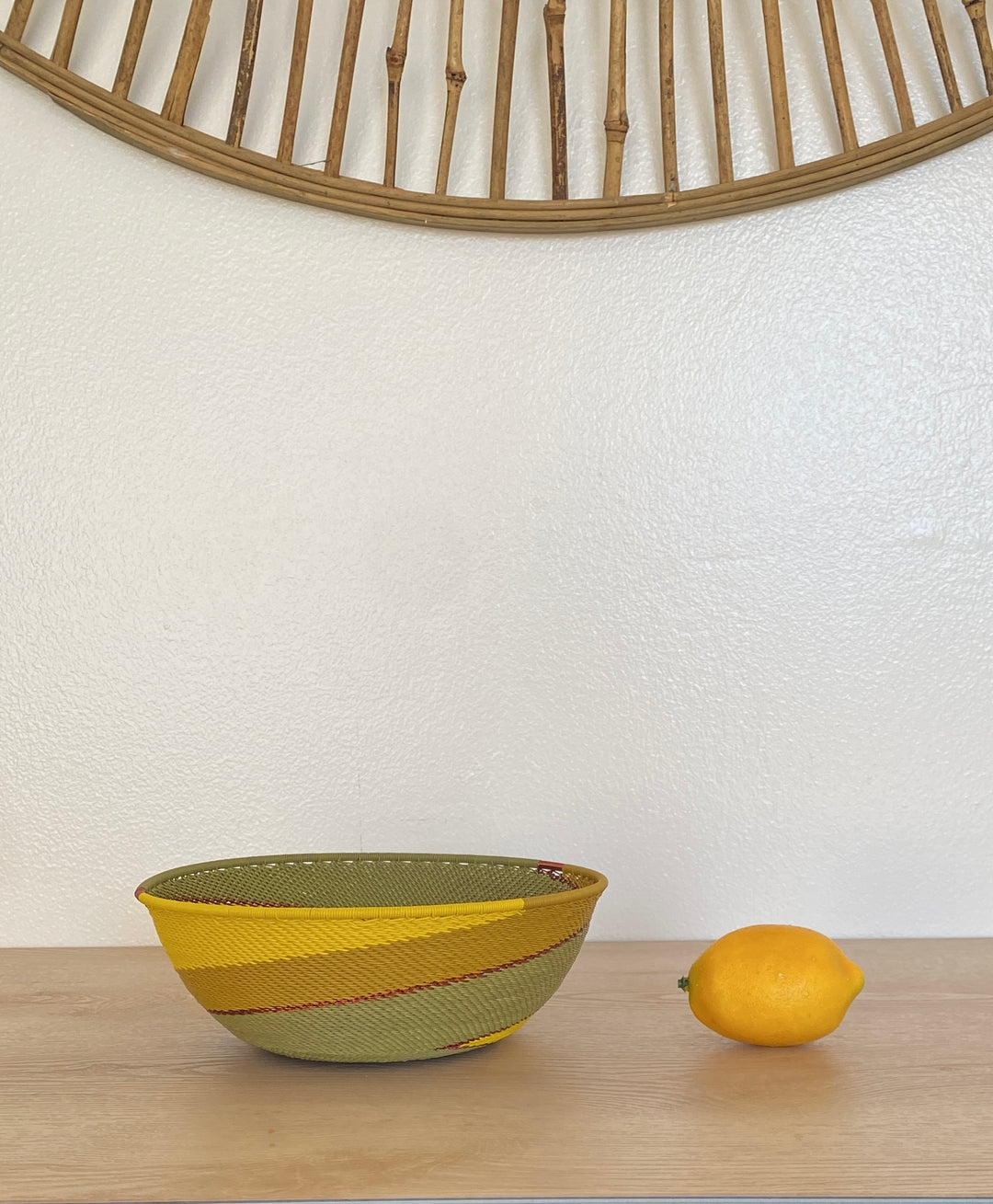 Papaya Zulu Bowl handwoven in South Africa with sunny yellow and papaya orange in a diagonal stripe pattern.