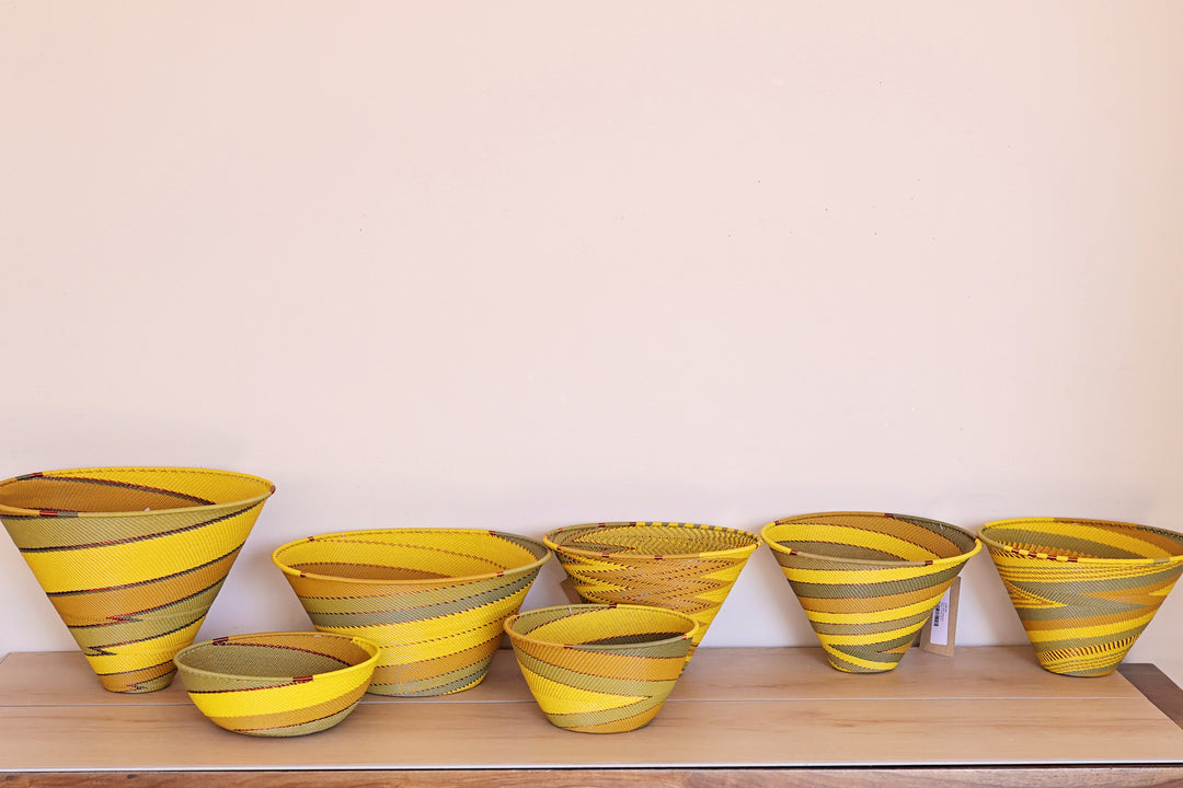 Papaya Zulu Bowl handwoven in South Africa with sunny yellow and papaya orange in a diagonal stripe pattern.
