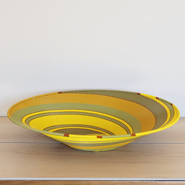 Papaya Zulu Extra Large Shallow Basket handwoven in South Africa with sunny yellow and papaya orange in a diagonal stripe pattern.