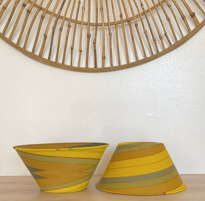 Papaya Zulu Medium Deep Funnel Bowl handwoven in South Africa with sunny yellow and papaya orange in a diagonal stripe pattern.