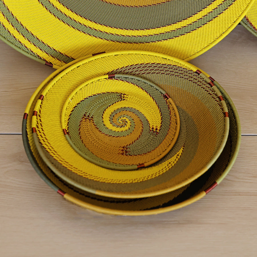 Papaya Zulu Medium Shallow Basket handwoven in South Africa with sunny yellow and papaya orange in a diagonal stripe pattern.
