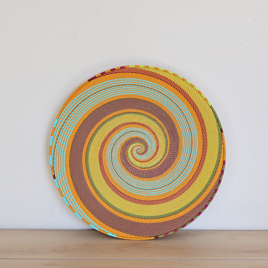Pastel Zulu Extra Large Shallow Basket handwoven in South Africa with vibrant multicolor wire in an intricate spiral pattern.