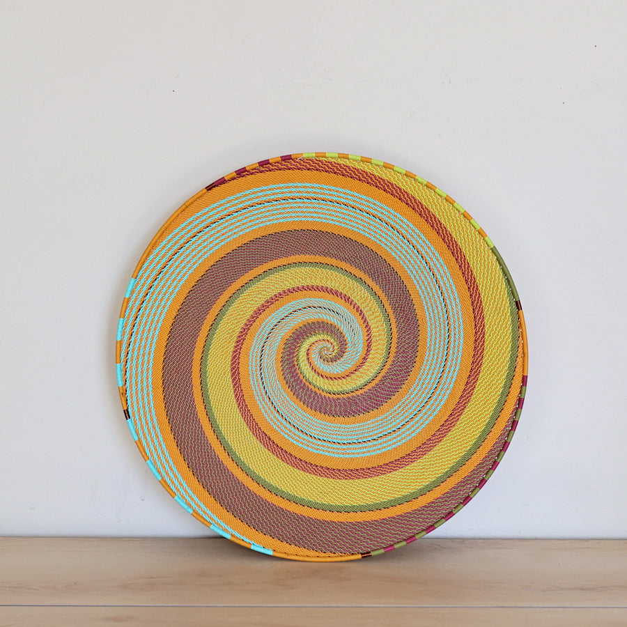 Pastel Zulu Extra Large Shallow Basket handwoven in South Africa with vibrant multicolor wire in an intricate spiral pattern.