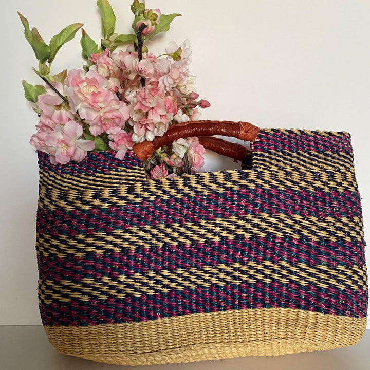 Woven multicolored bag with pink flowers on a white background