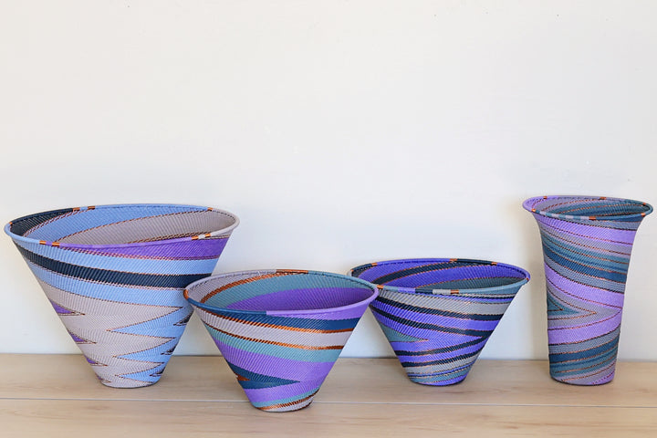 Purple Zulu Medium Deep Funnel Bowl handwoven in South Africa with layered shades of purple in a diagonal stripe pattern.