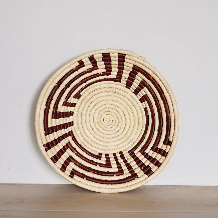 Handwoven Radiant Weave Bukedo and Raffia bowl handmade in Uganda featuring a burgundy and natural radiating woven pattern for fair trade home décor.