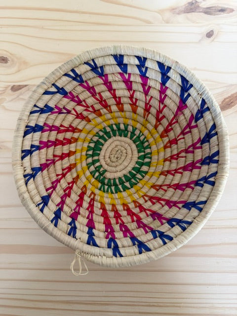 Close-up of colorful handwoven raffia detailing on a Rainbow Raffia Fruit Basket.