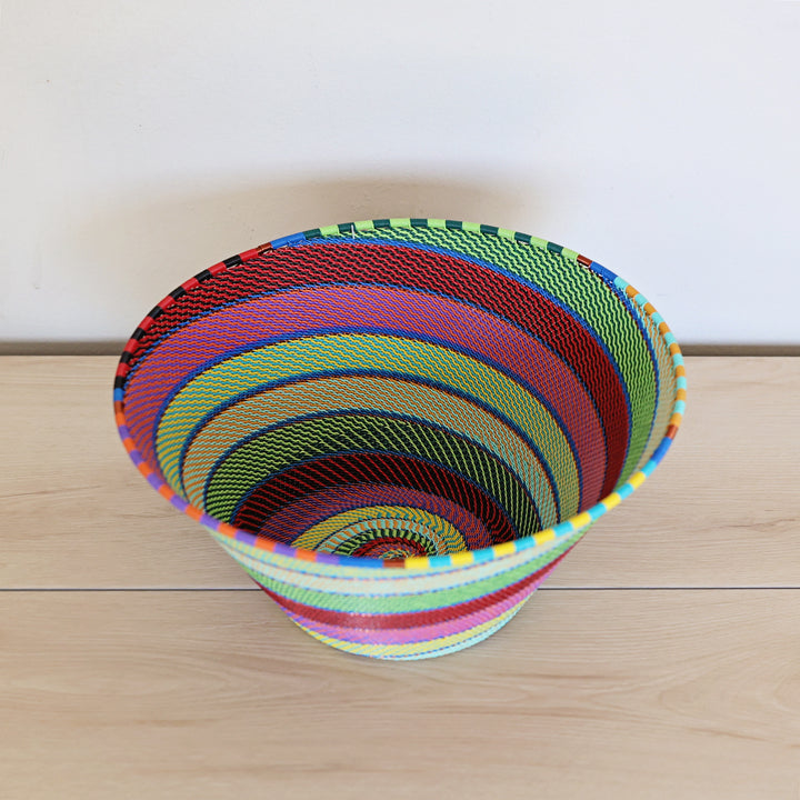 Rainbow Zulu Deep Bowl handwoven in South Africa with vibrant multicolor diagonal stripes and copper wire accents.