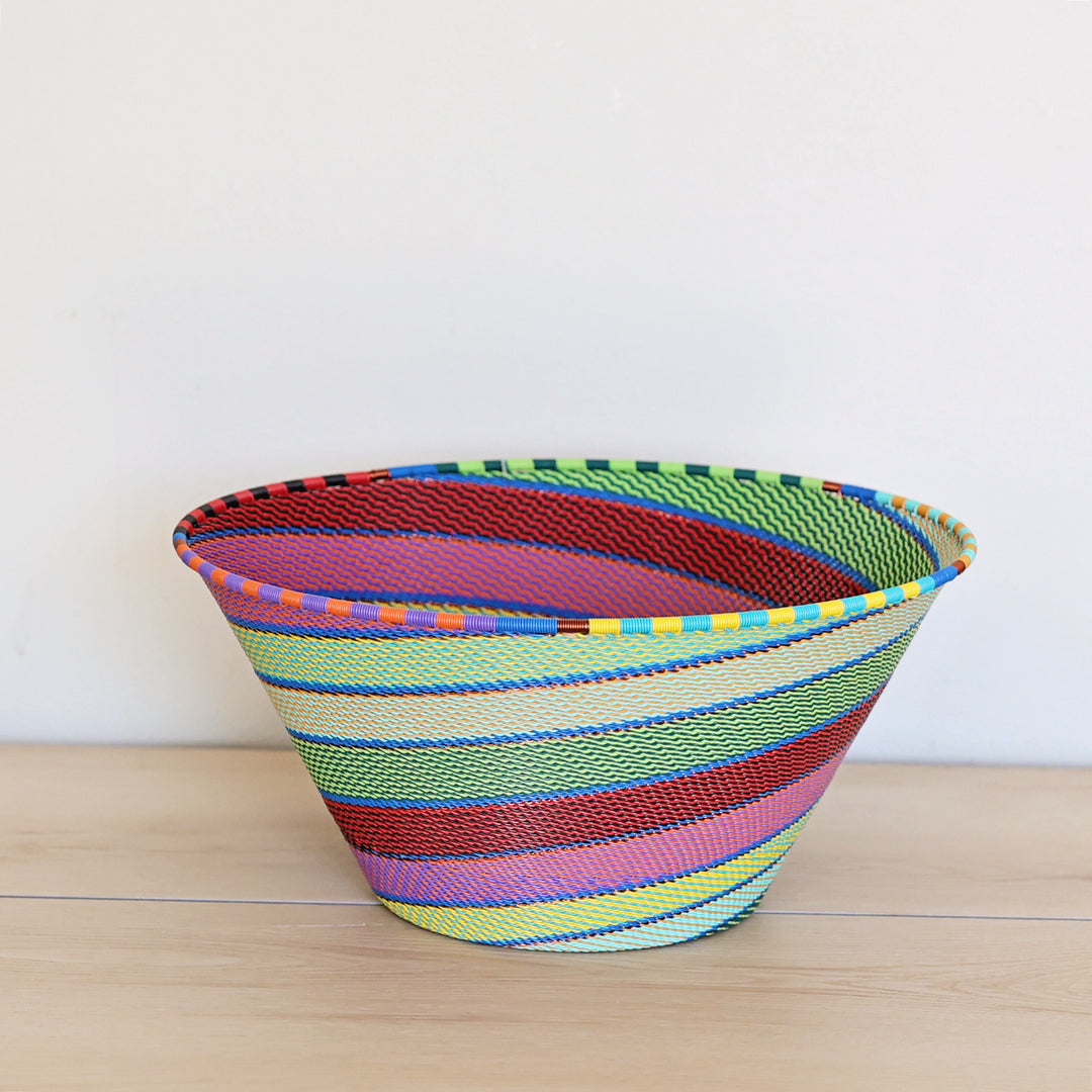 Side view of a Rainbow Zulu Deep Bowl featuring colorful handwoven wire craftsmanship by South African artisans.