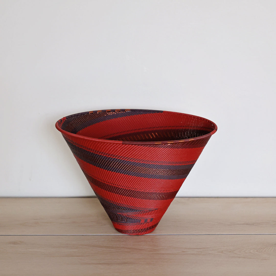 Red Garnet Zulu wire large deep funnel basket handwoven in South Africa with deep red, burgundy and dark diagonal woven stripes.