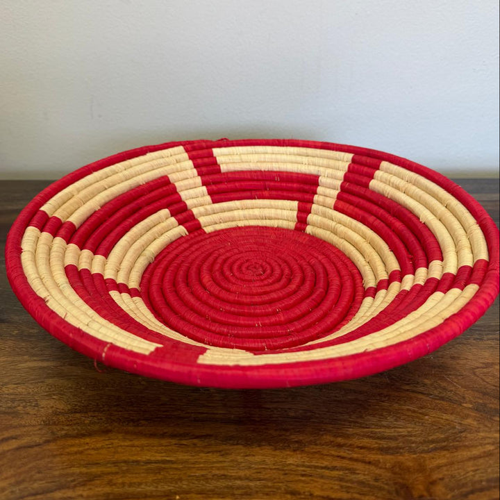 Artisan-made Red Radiance Bukedo and Raffia bowl handwoven in Uganda, showcasing bold red and natural woven patterns for wall décor and tabletop styling.