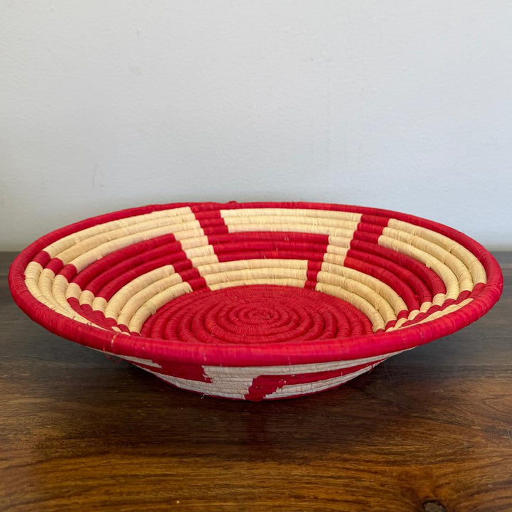 Side view of a Red Radiance Bukedo and Raffia bowl handcrafted in Uganda from banana leaf stalks and palm raffia in vibrant red and natural tones.