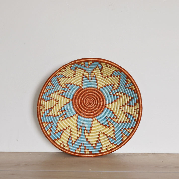 Handwoven Rwanda Sisal Basket in light blue, orange, and light yellow colors. Perfect for hosting and decorating. 