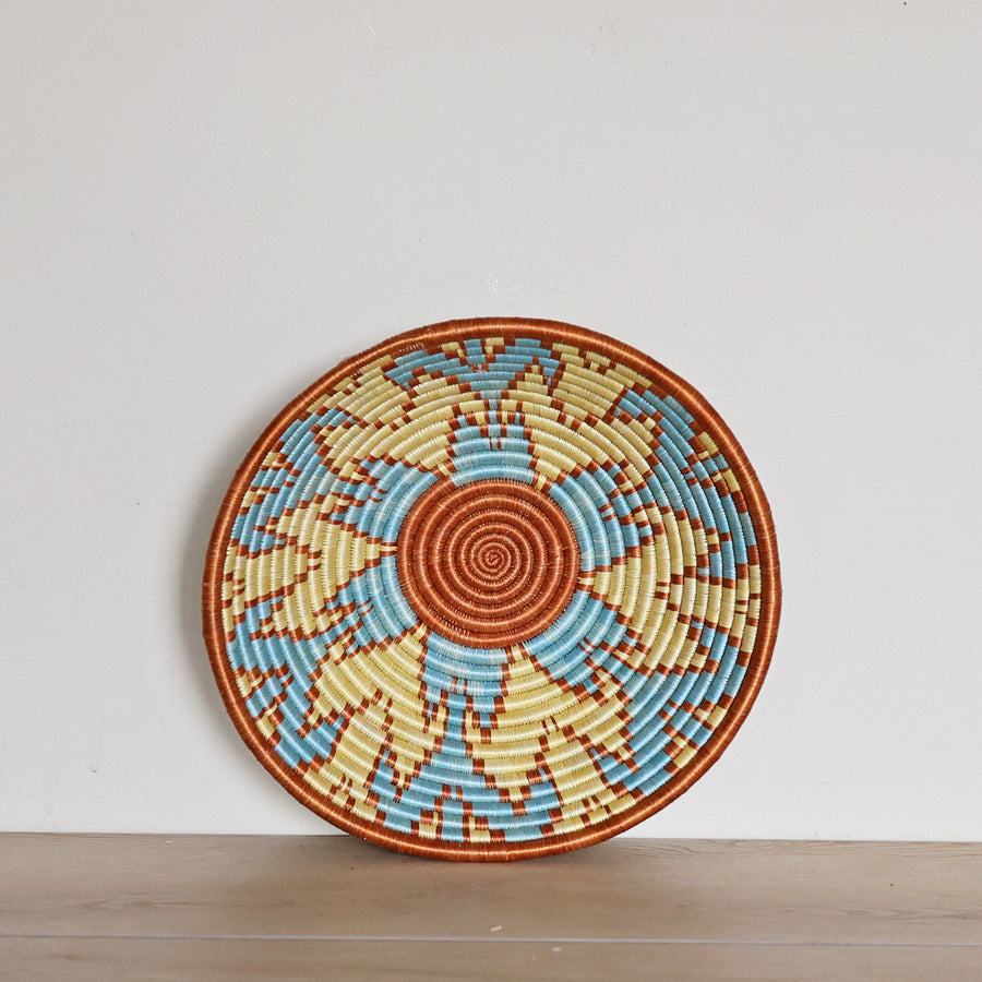 Handwoven Rwanda Sisal Basket in light blue, orange, and light yellow colors. Perfect for hosting and decorating. 