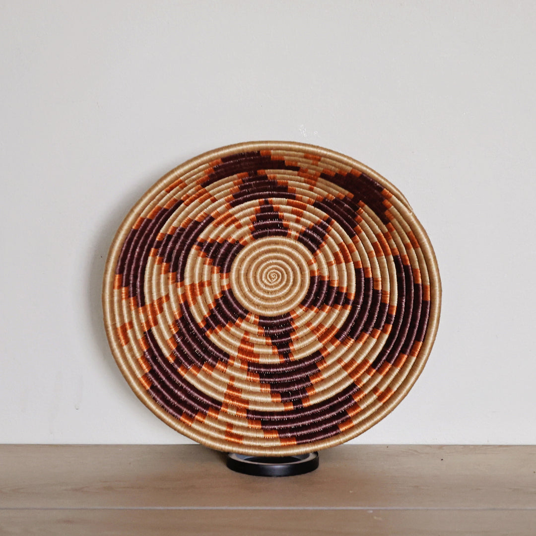 Handwoven Rwanda sisal basket in natural, chocolate, and orange geometric patterns for fair trade wall décor and artisan home styling.