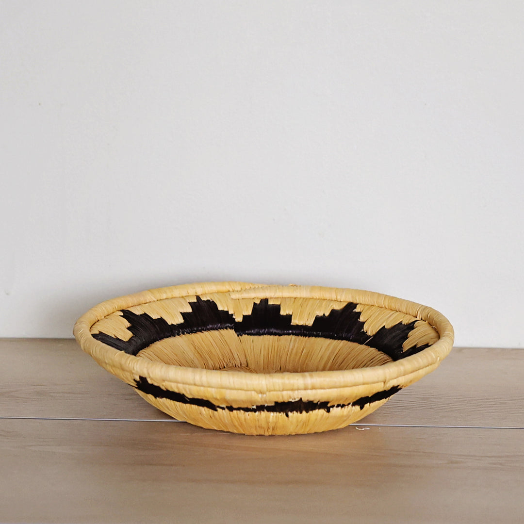 Side view of the black and yellow Bukedo basket, handmade by fair-trade artisans. 