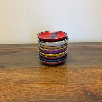 Stacked tower of assorted colorful Kisii stone bowls hand-carved in Kenya